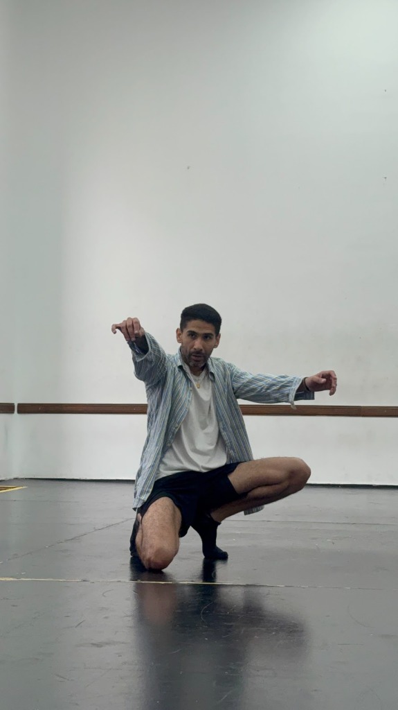 Bailarín de LEX en cuclillas y gesto escénico frontal